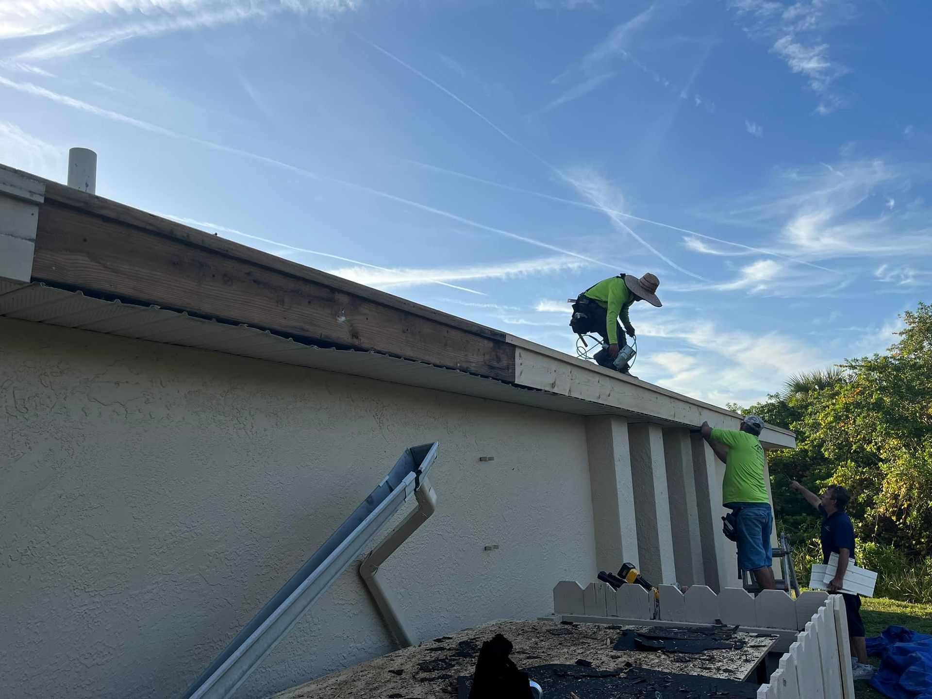 Two men are working on the roof of a house