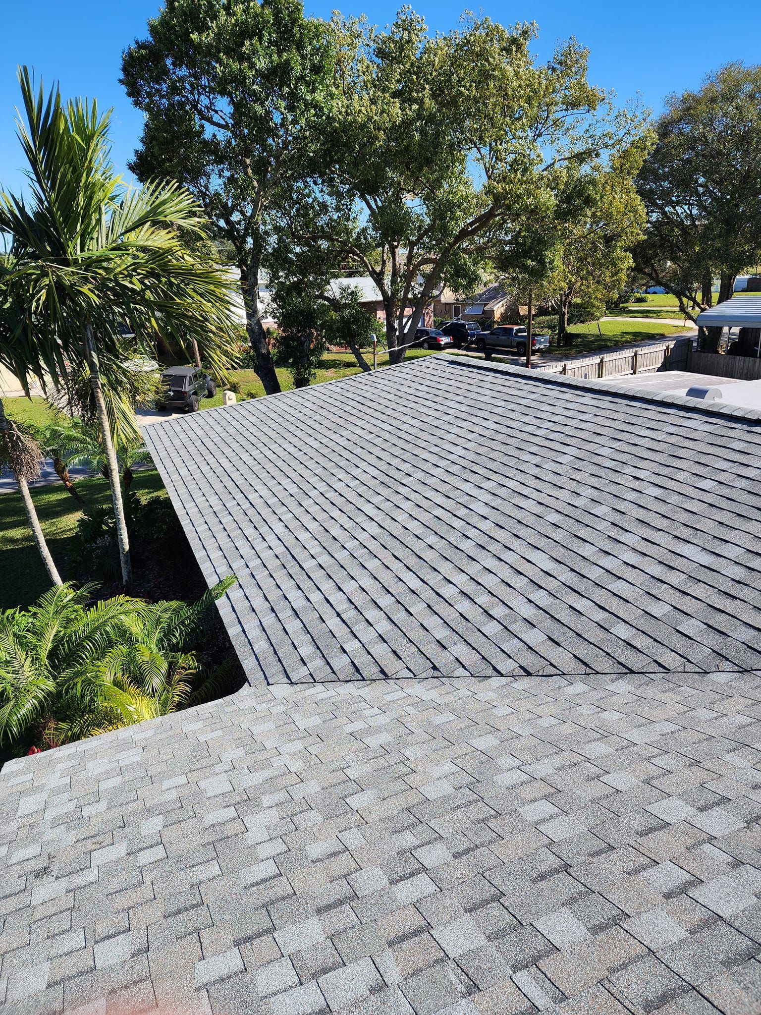 A roof of a house with a lot of trees in the background.