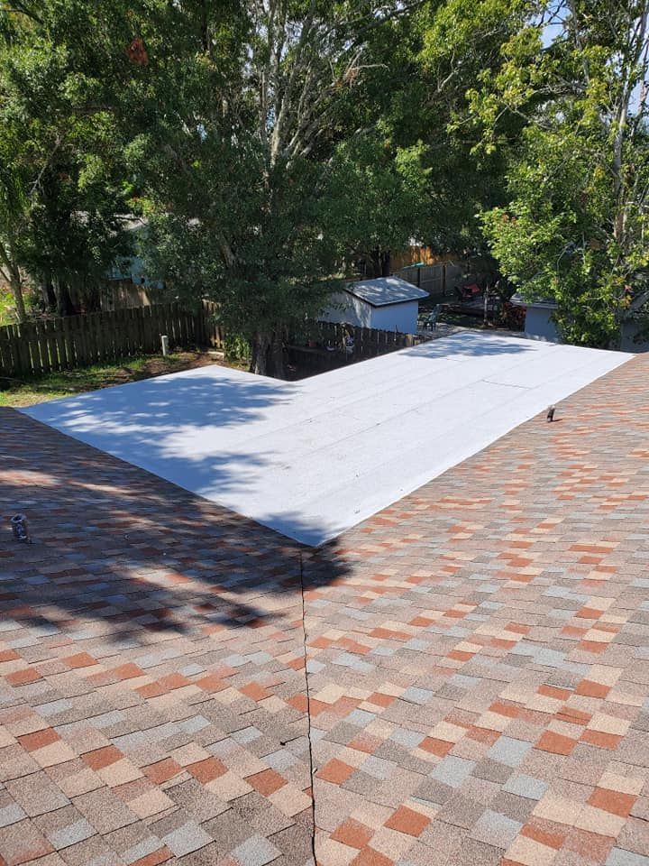 A large white tarp is sitting on top of a brick roof.