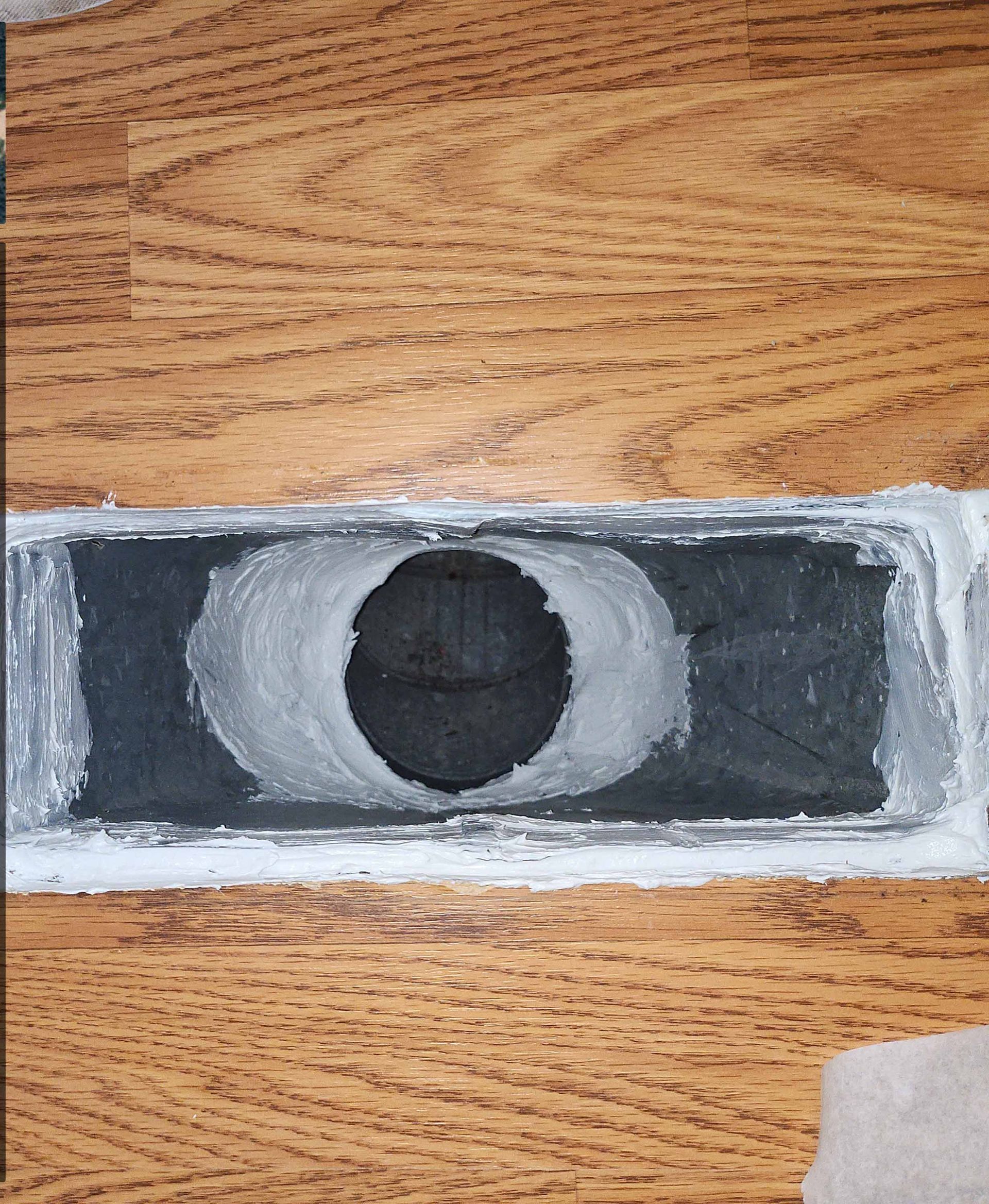 A black and white drawing of an eye on a wooden surface