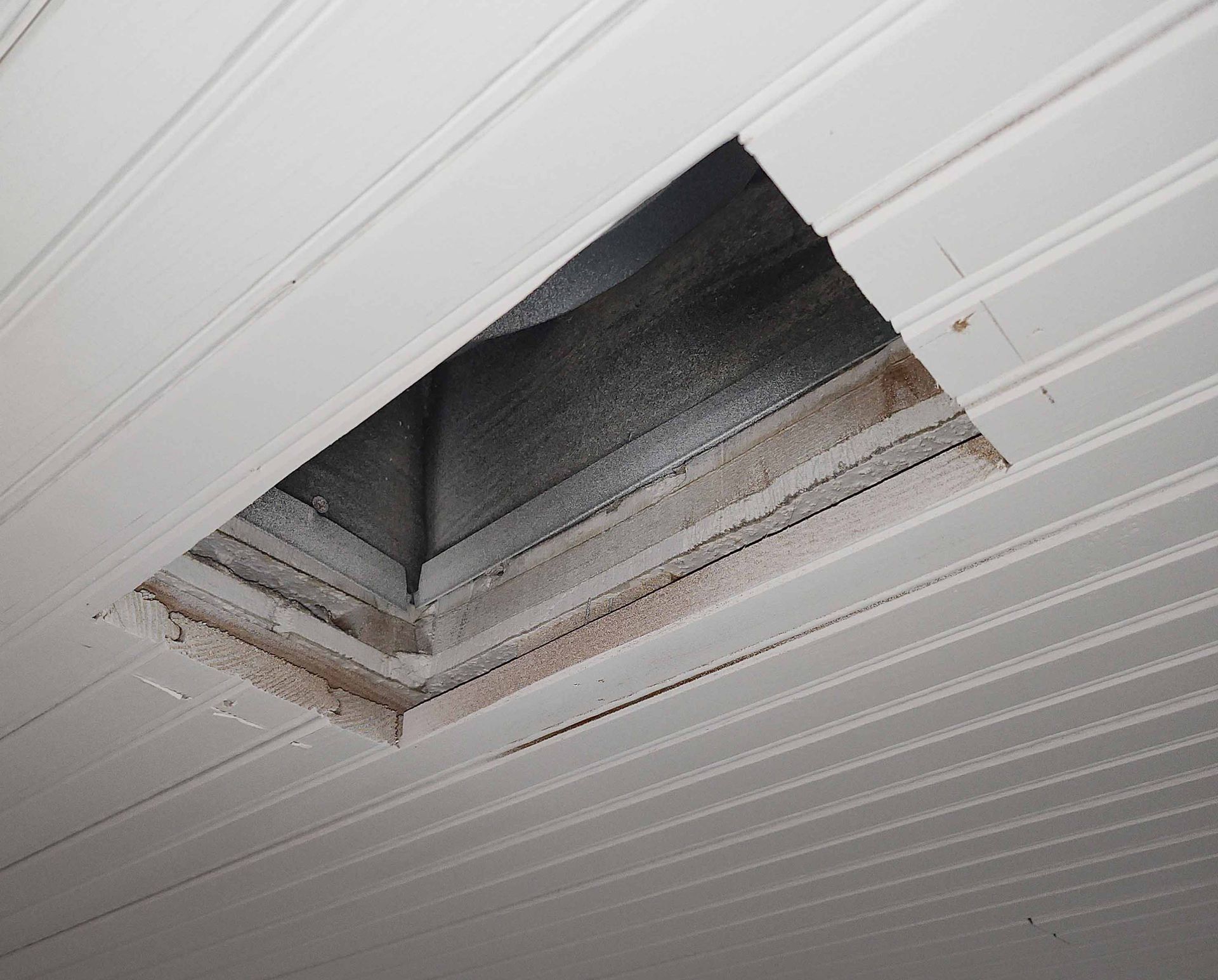 A white ceiling with a hole in it
