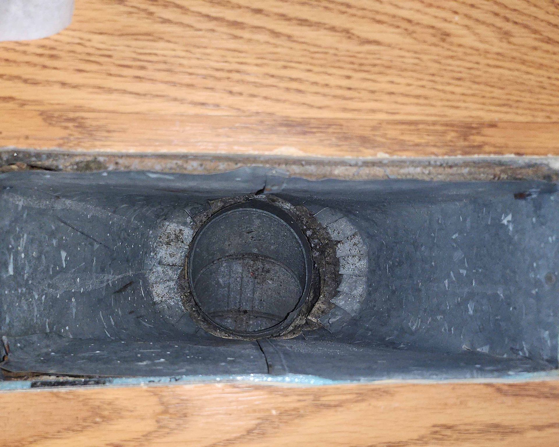 A piece of metal is sitting on top of a wooden table.