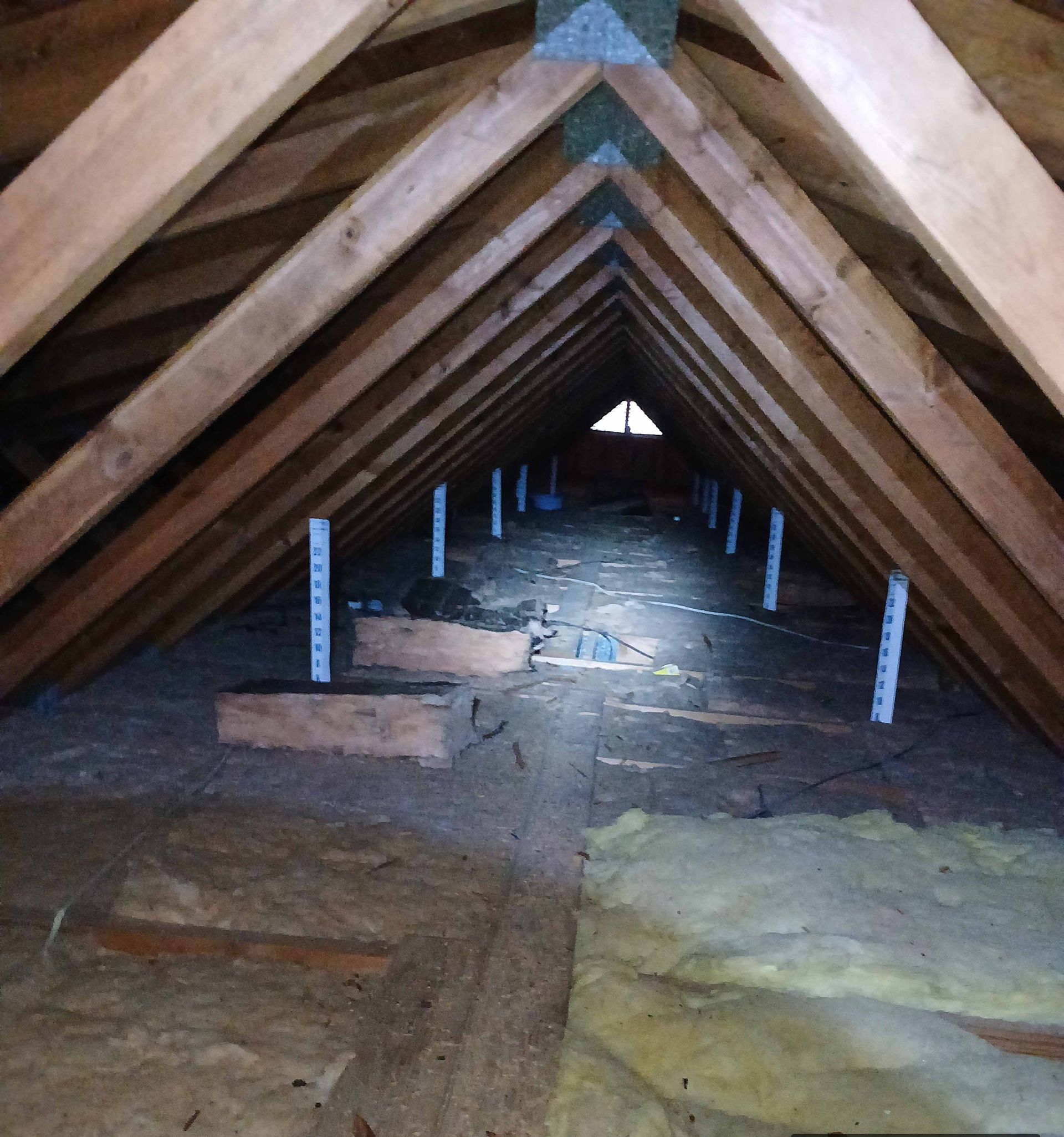 An attic with a lot of wooden beams and a window