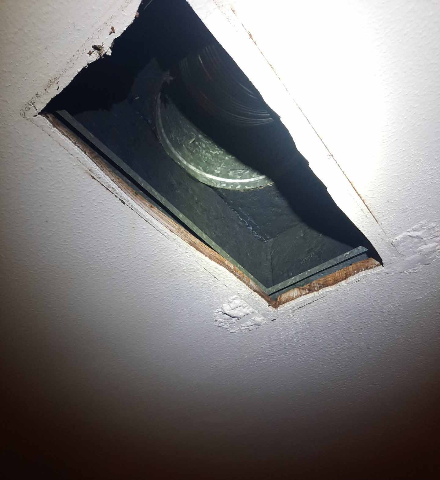 A hole in the ceiling with a light shining through it
