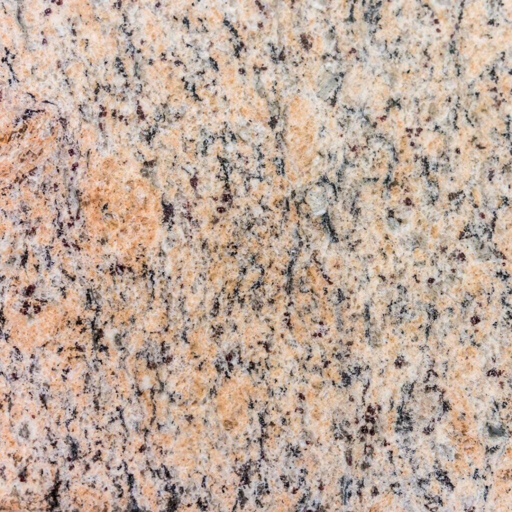 Close-up of granite surface with beige, black, and gray speckled patterns.