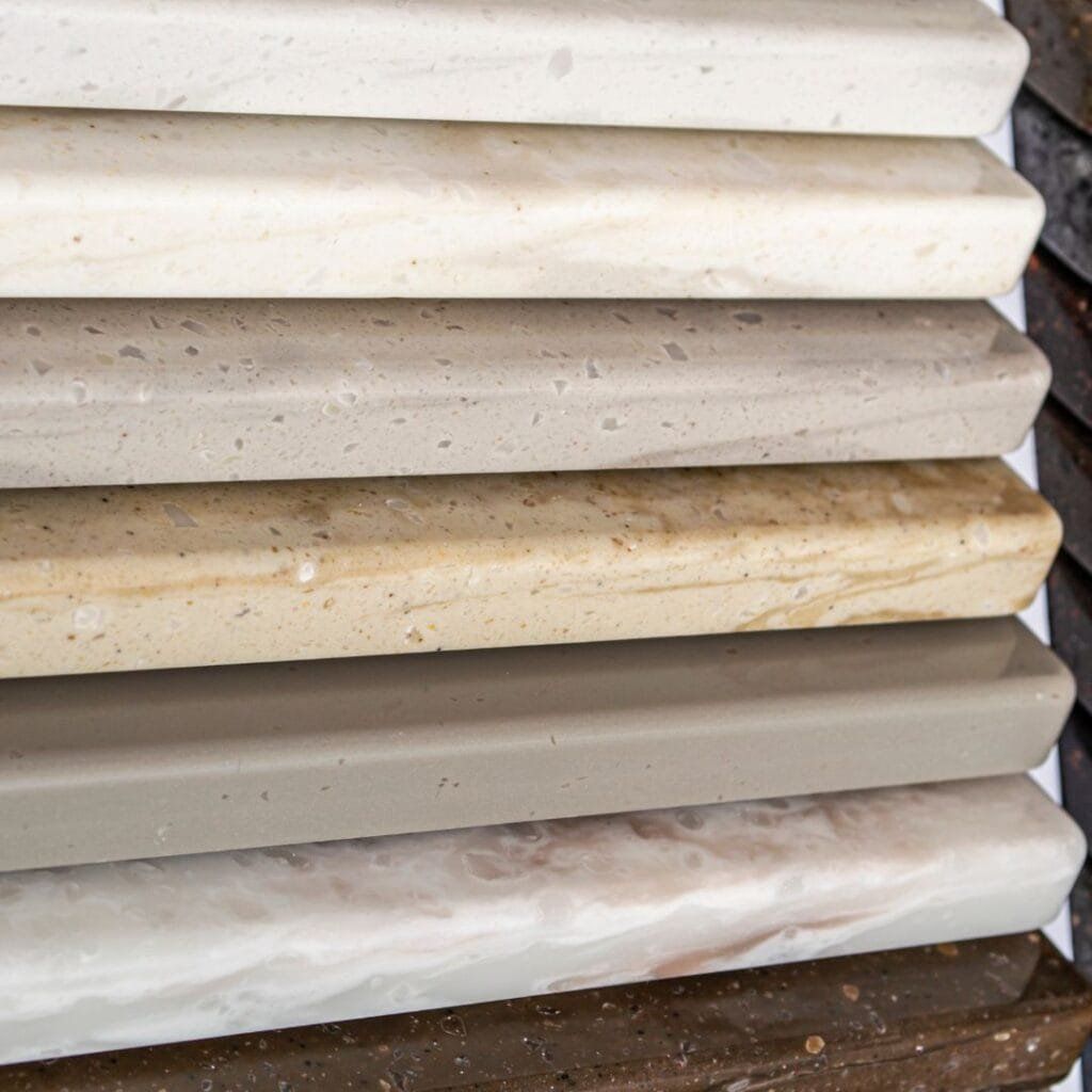 Close-up of a stack of neutral-colored stone countertop samples.
