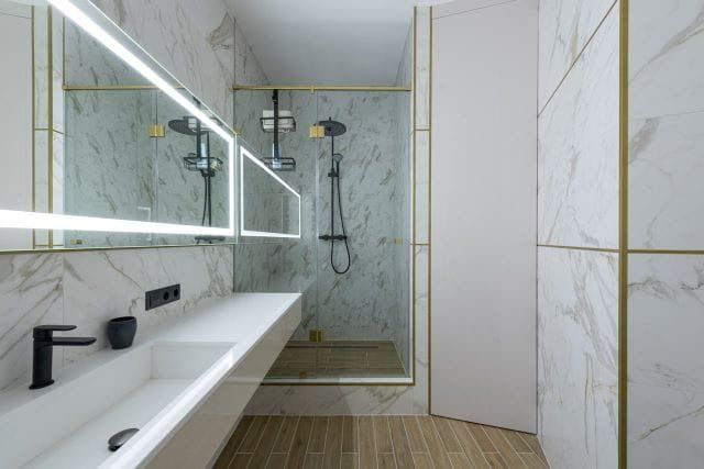 Modern bathroom with marble walls, a walk-in shower, and a floating vanity.