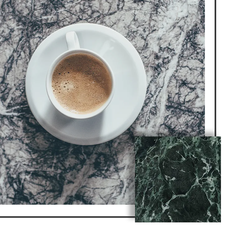 Cup of coffee on white saucer, on a marble countertop with gray and white veining.