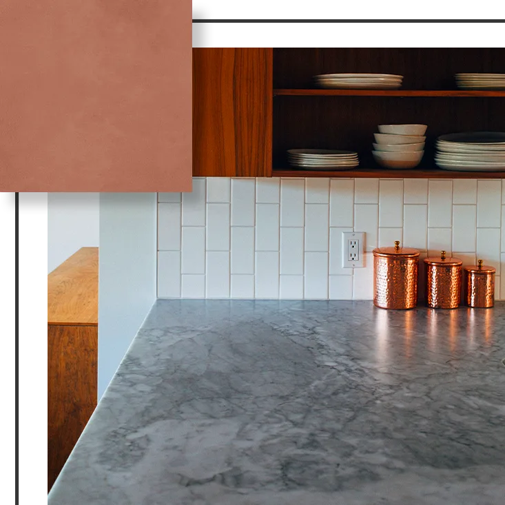Kitchen with gray countertop, white backsplash, wooden cabinets, and copper canisters.