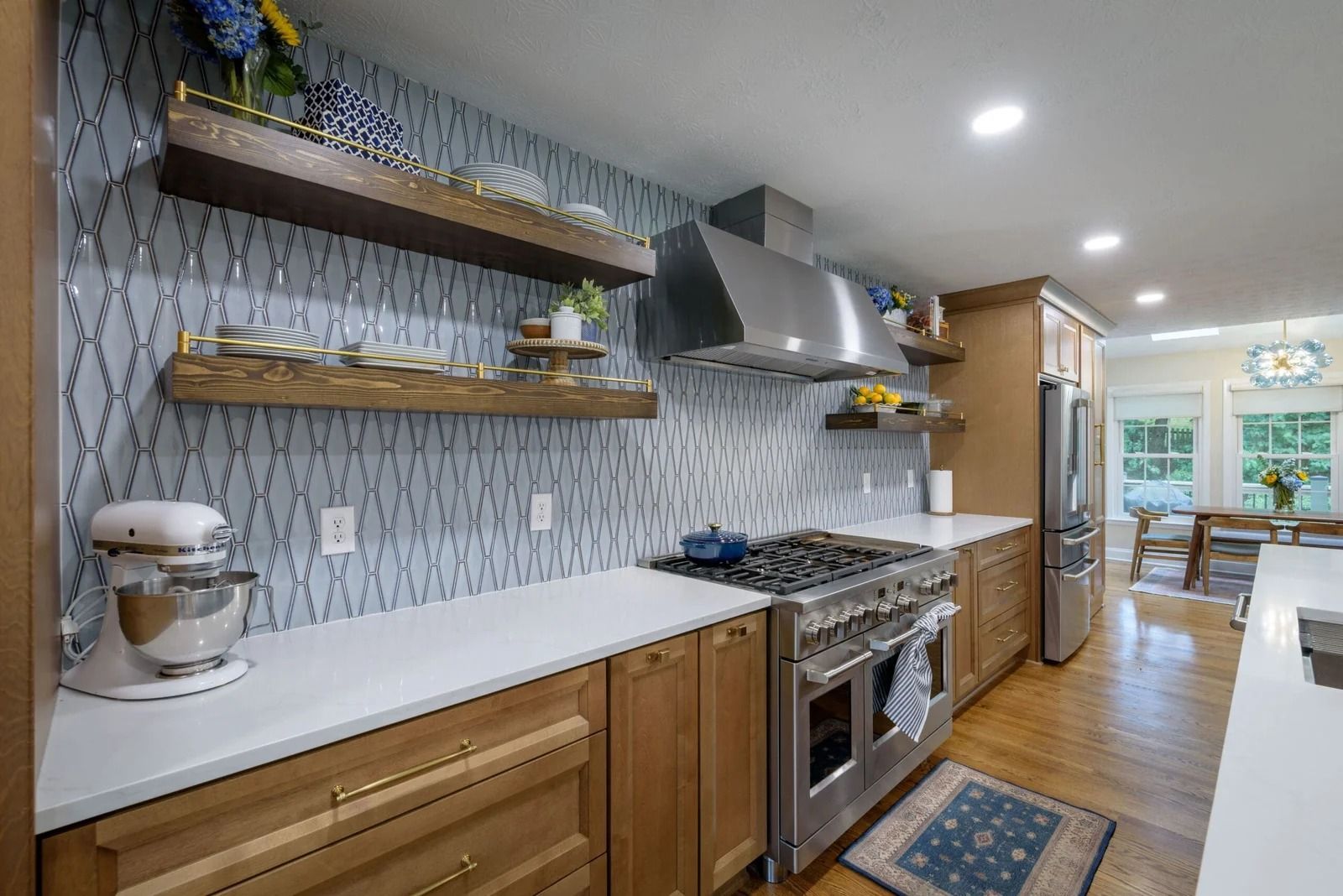 Kitchen with wooden cabinets, stainless steel appliances, and patterned backsplash.