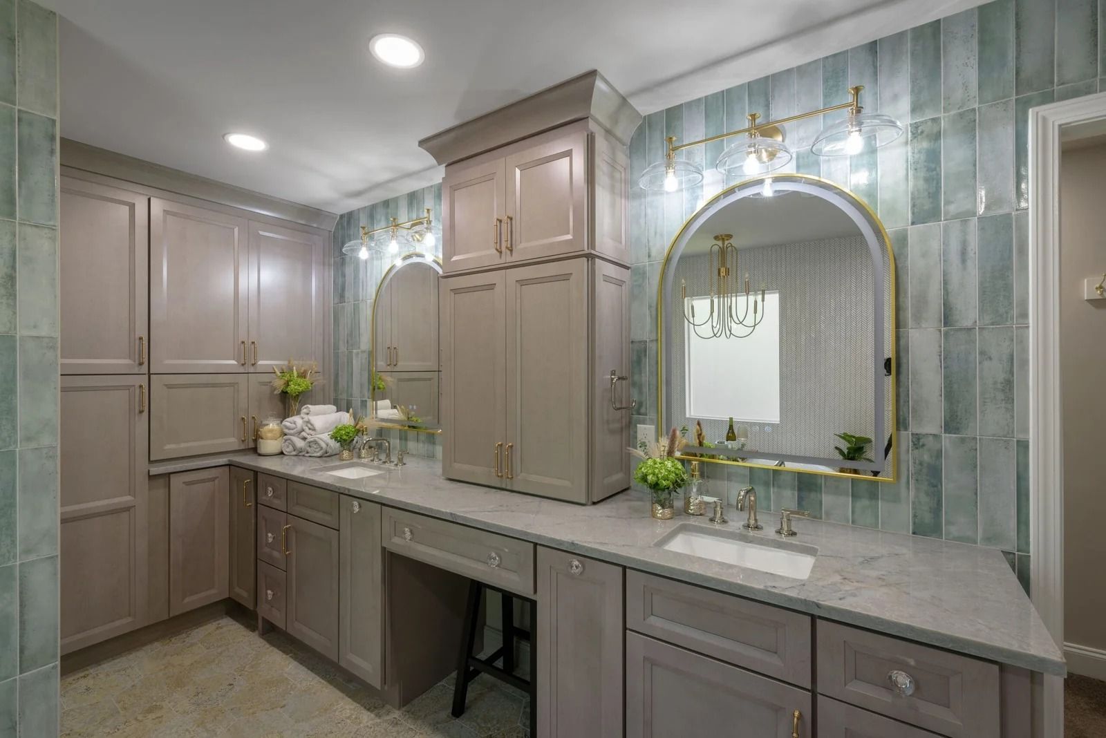 Bathroom with light grey cabinets, blue tile wall, gold accents, and large mirrors.