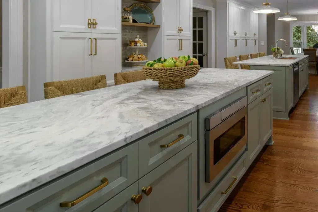 Kitchen with marble countertops, gray cabinets, and a microwave built-in the island.