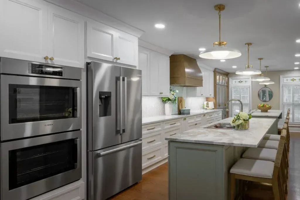 Modern kitchen with stainless steel appliances, white cabinets, and a large island with seating.