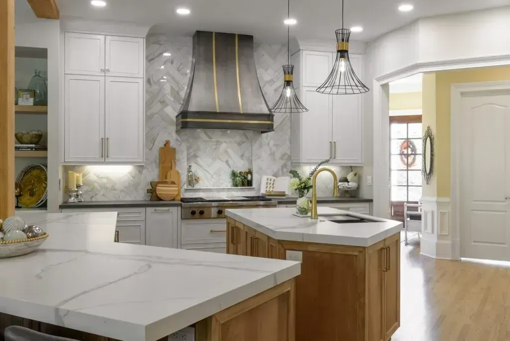 Modern kitchen with white cabinets, marble backsplash, wooden island, and stainless steel range hood.