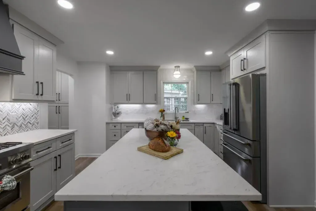 Gray and white kitchen with island, cabinets, and stainless steel appliances.