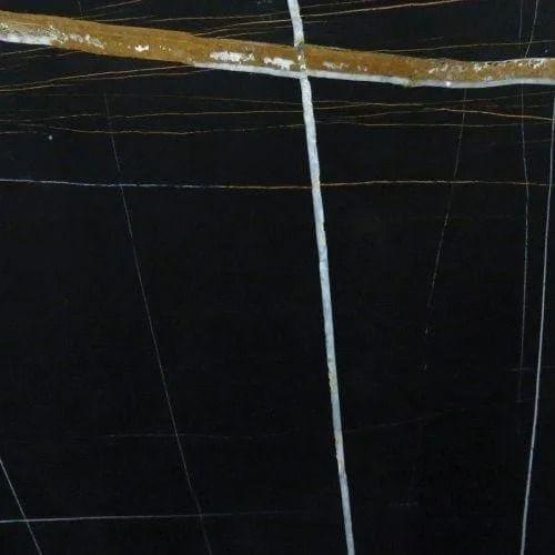 Black marble surface with white and gold veining.