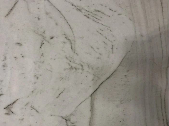 White marble surface with gray veins and patterns.
