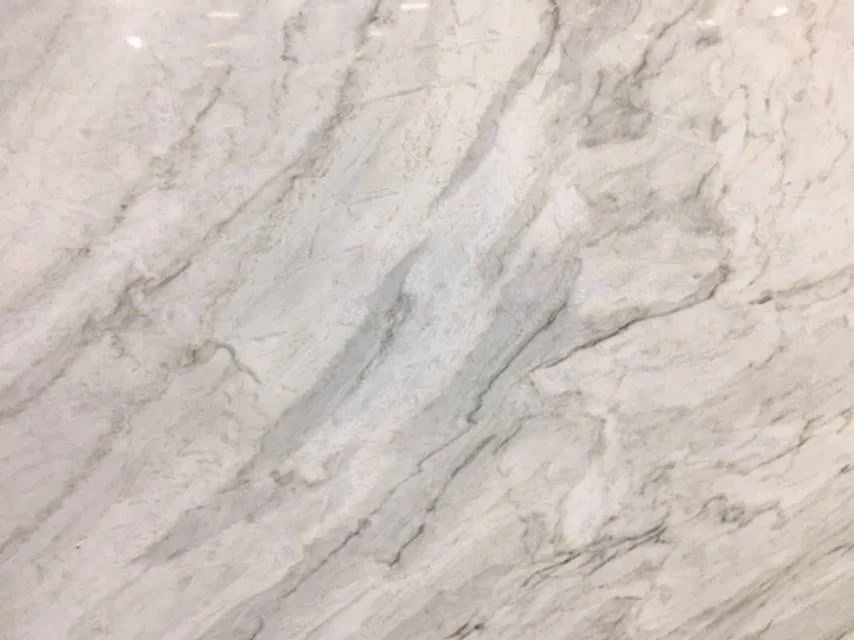 White and gray marble surface with swirling veins and subtle variations in color.