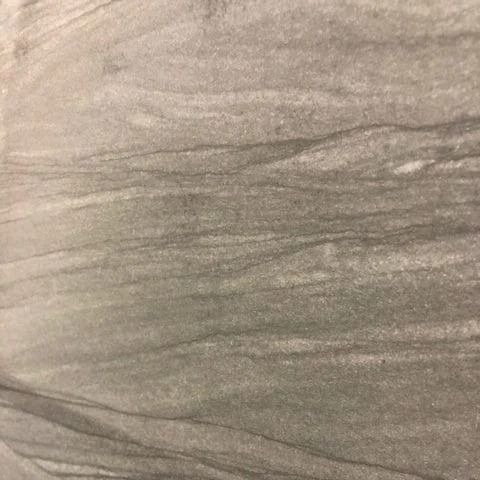 Gray stone tile with swirling, wavy grain pattern.