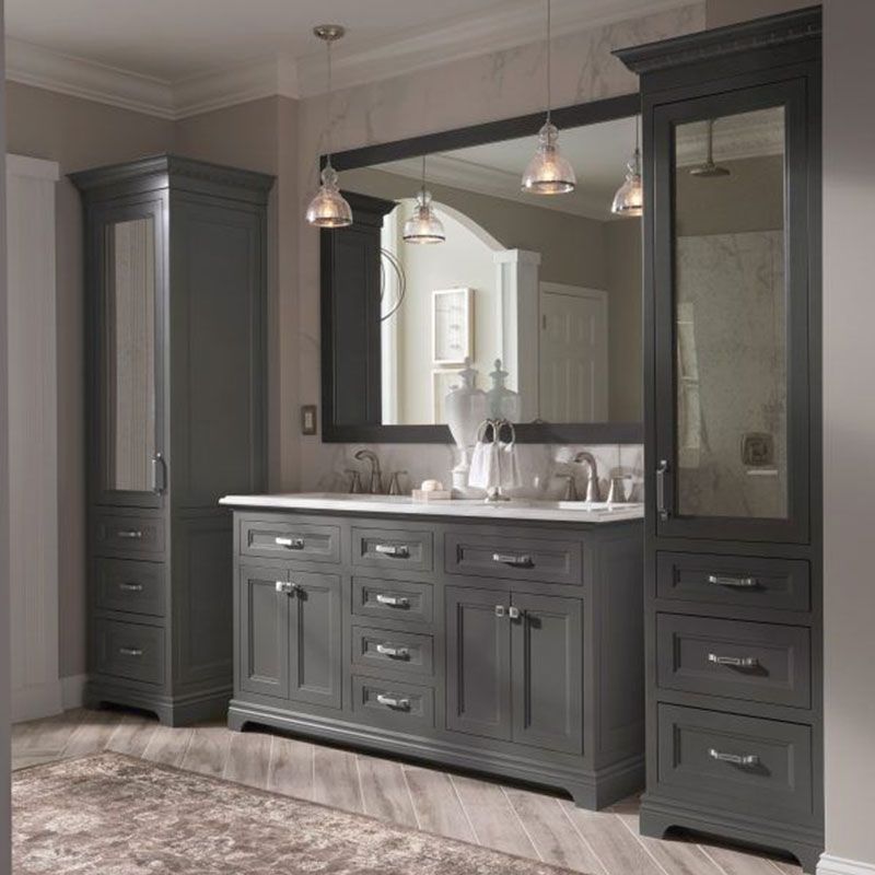 A bathroom with gray cabinets and a large mirror