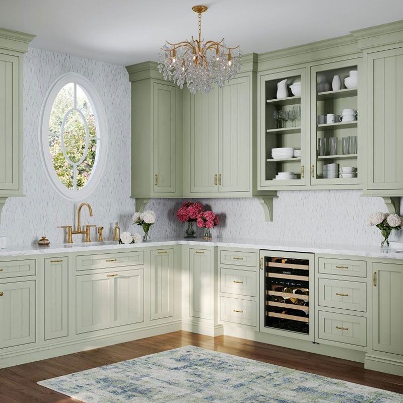 An elegant kitchen with light green cabinets