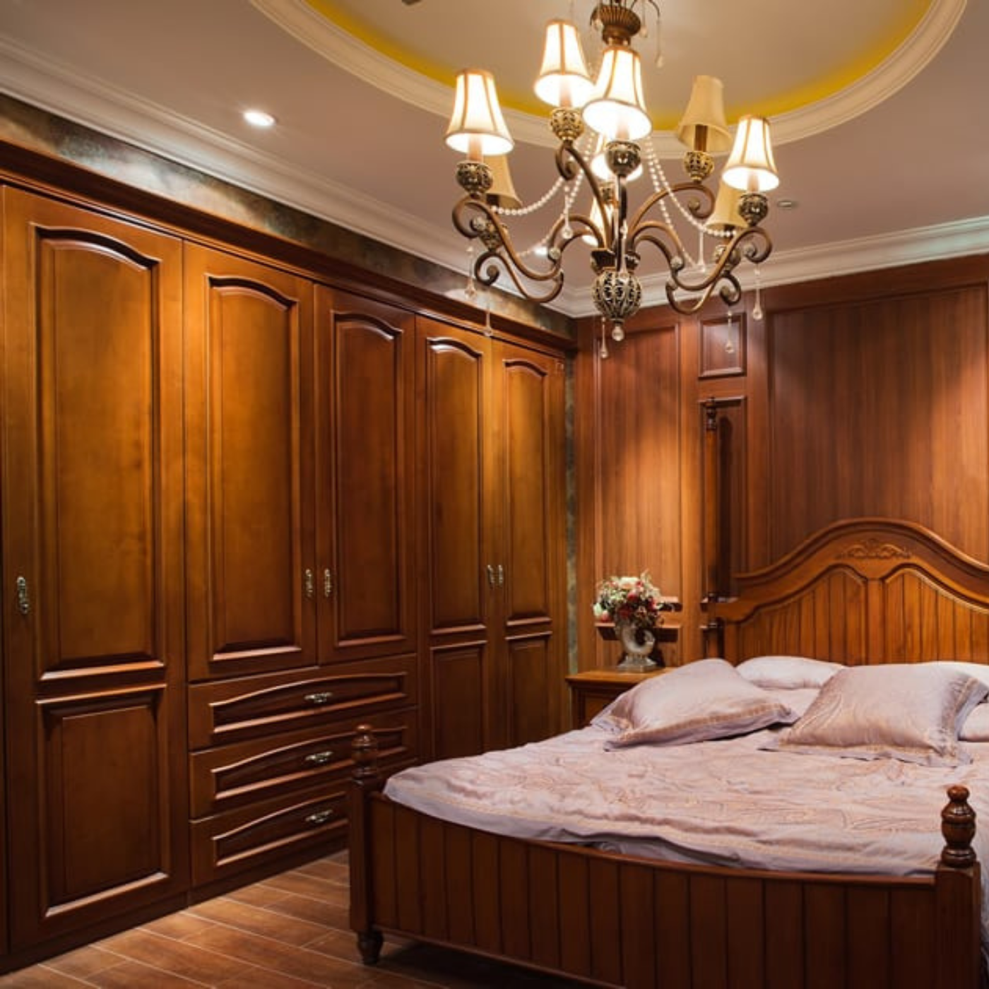 A bedroom with a bed and a chandelier hanging from the ceiling