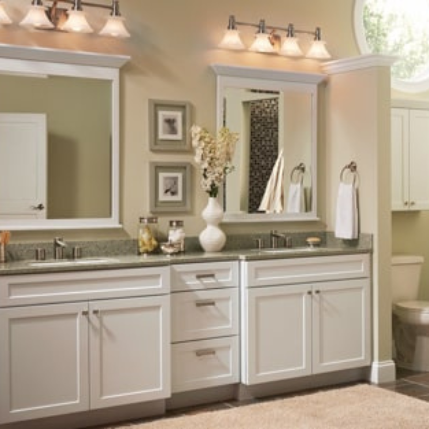 A bathroom with white cabinets and a toilet