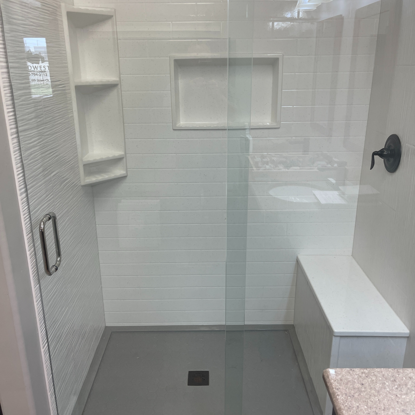 A bathroom with a walk in shower and a sink.