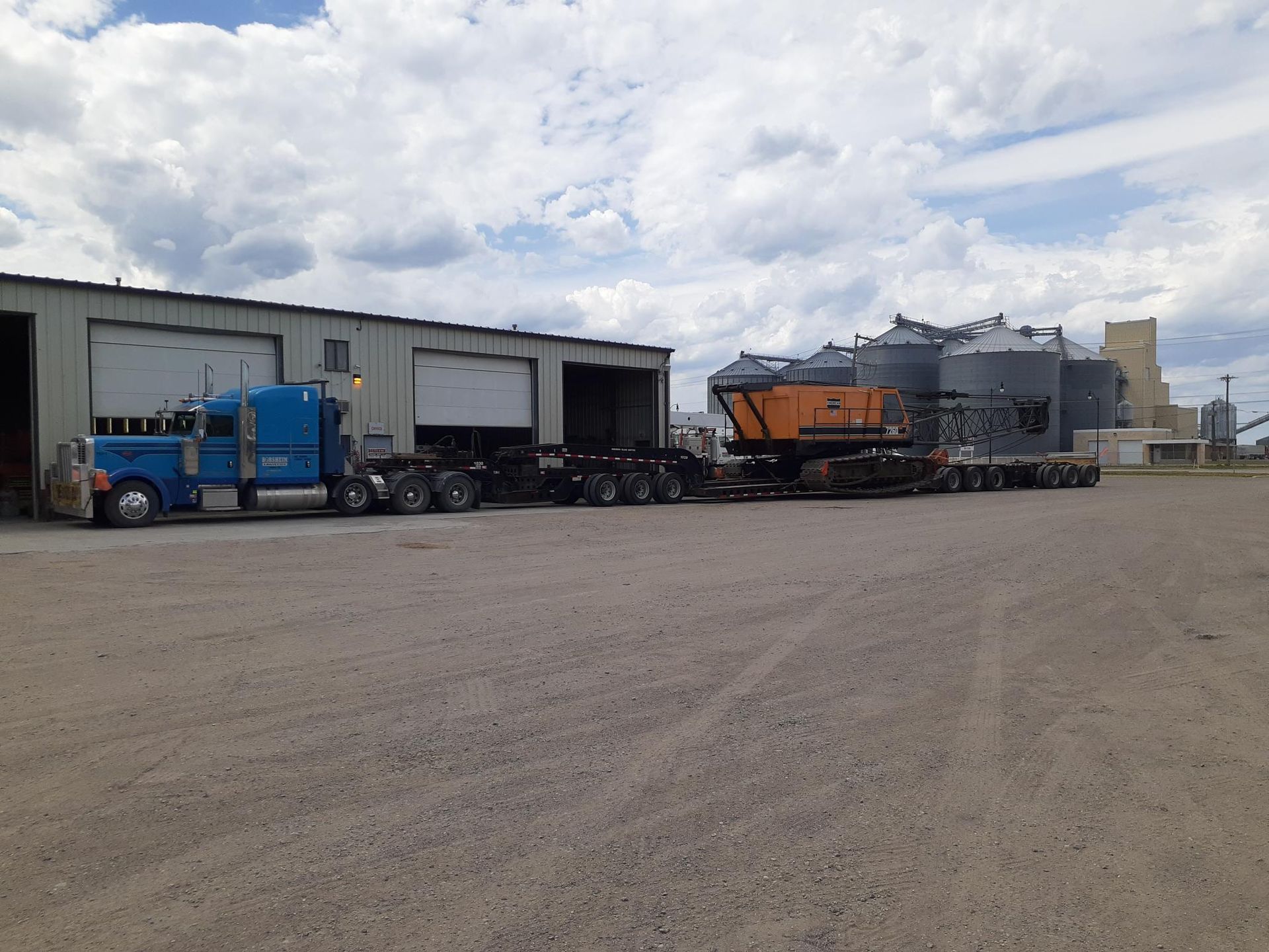 Blue truck transporting machinery