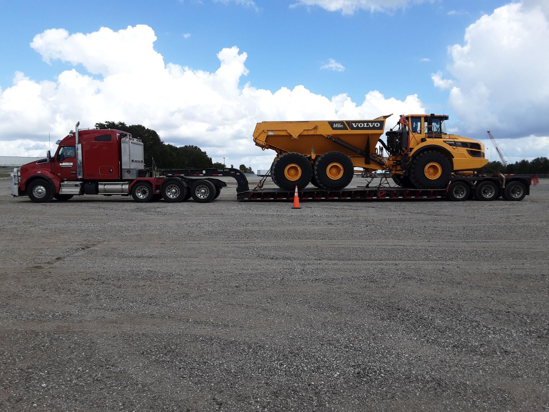 Heavy machinery loaded on a red truck