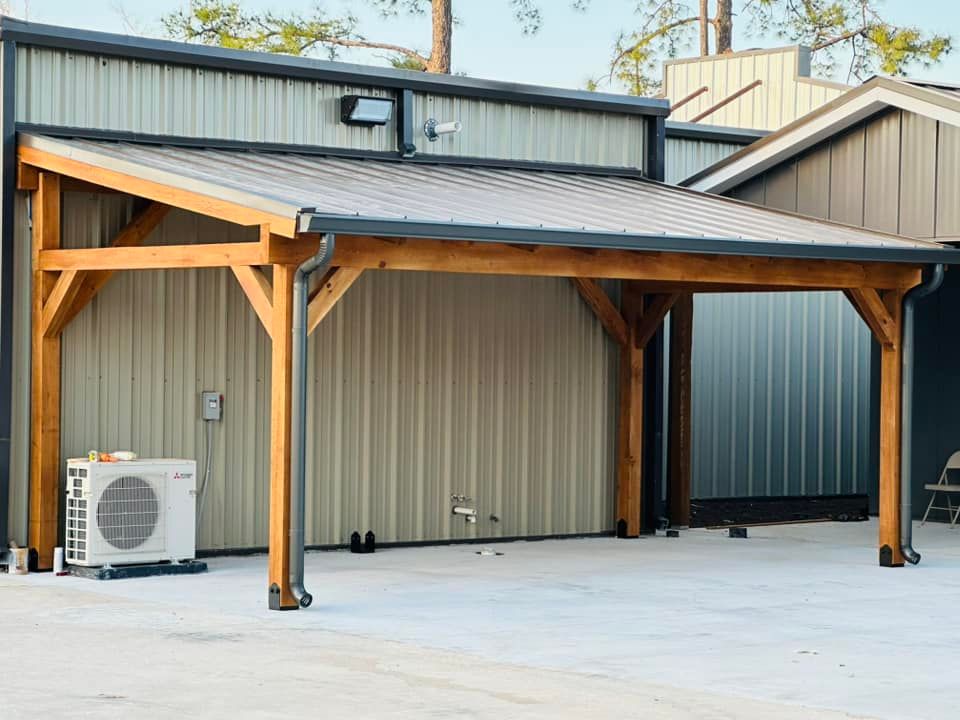 Covered outdoor parking area with wooden posts, black roof, and an air conditioner unit on a concrete pad