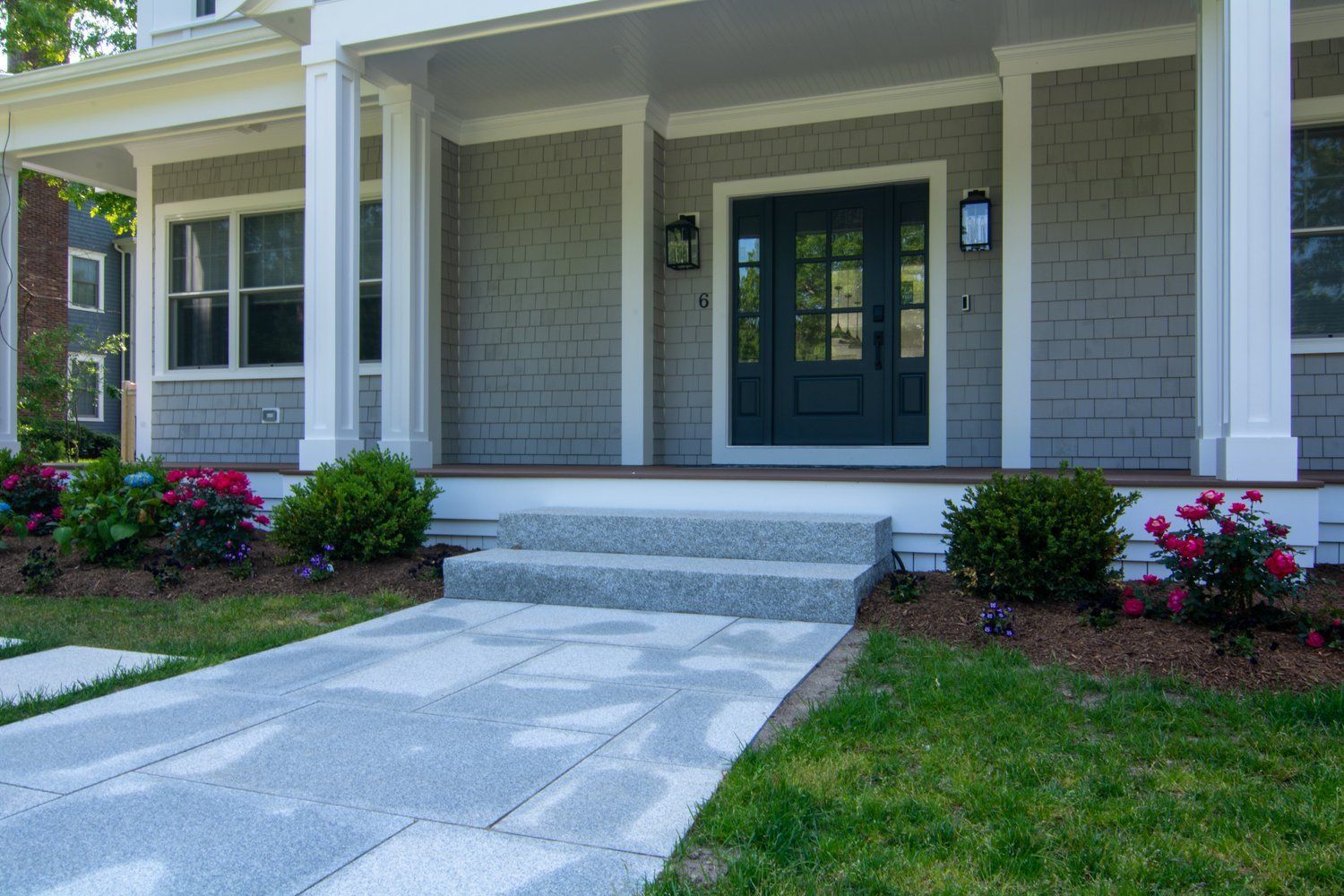 The front of a house with a porch and steps leading to the front door.