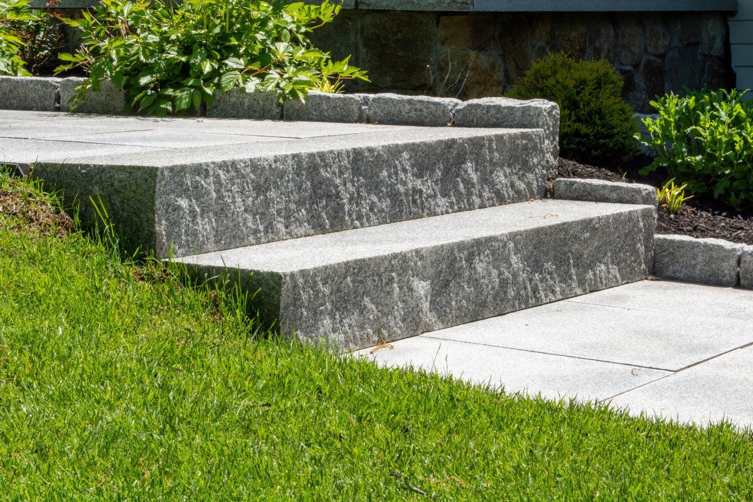 A set of stone steps leading up to a grassy hillside.
