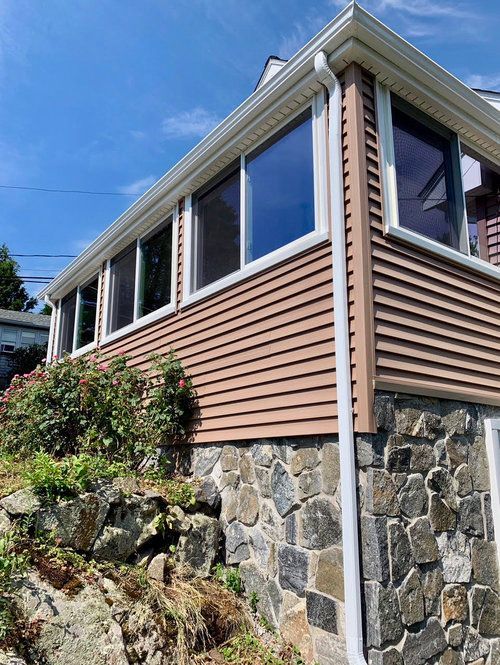 A house with a lot of windows is sitting on top of a hill.