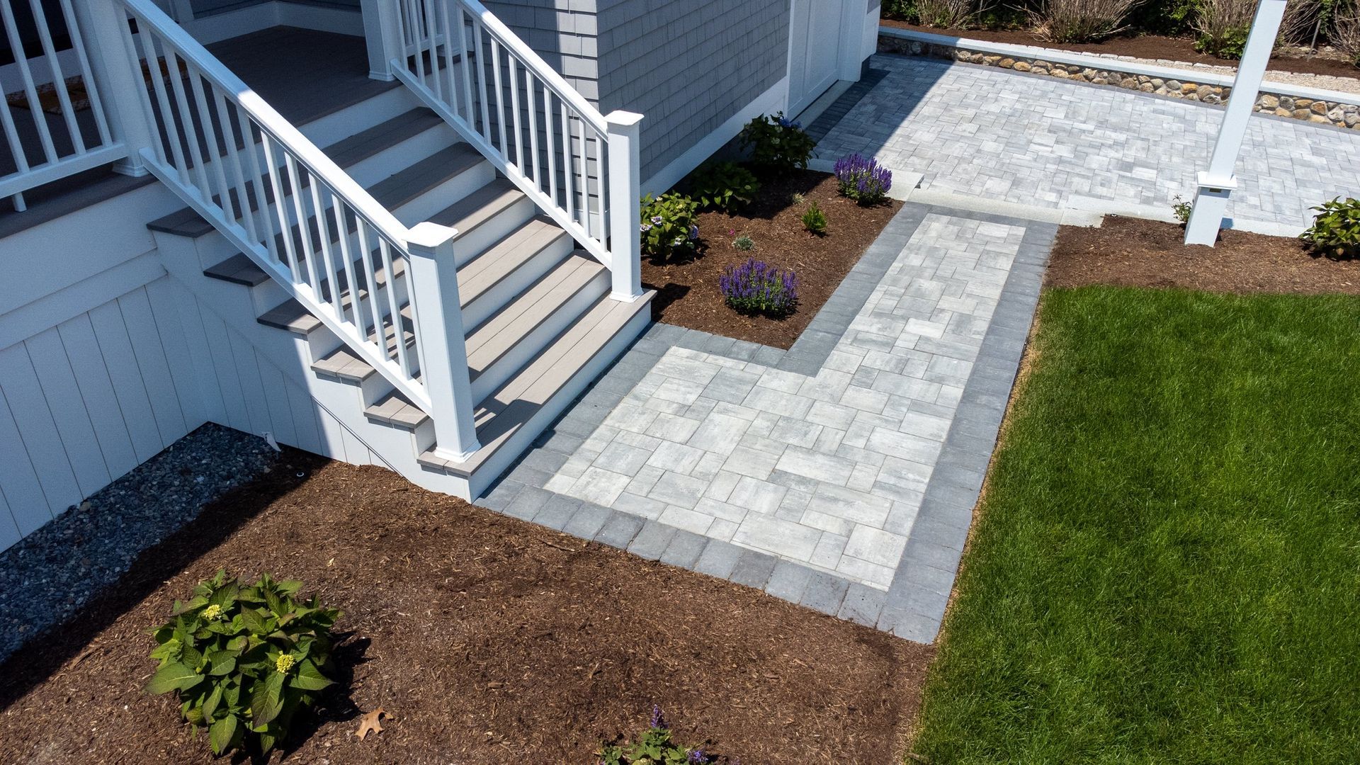 There is a walkway leading to the front of the house.