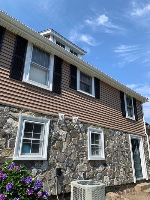 A house with a lot of windows and a air conditioner on the side of it.