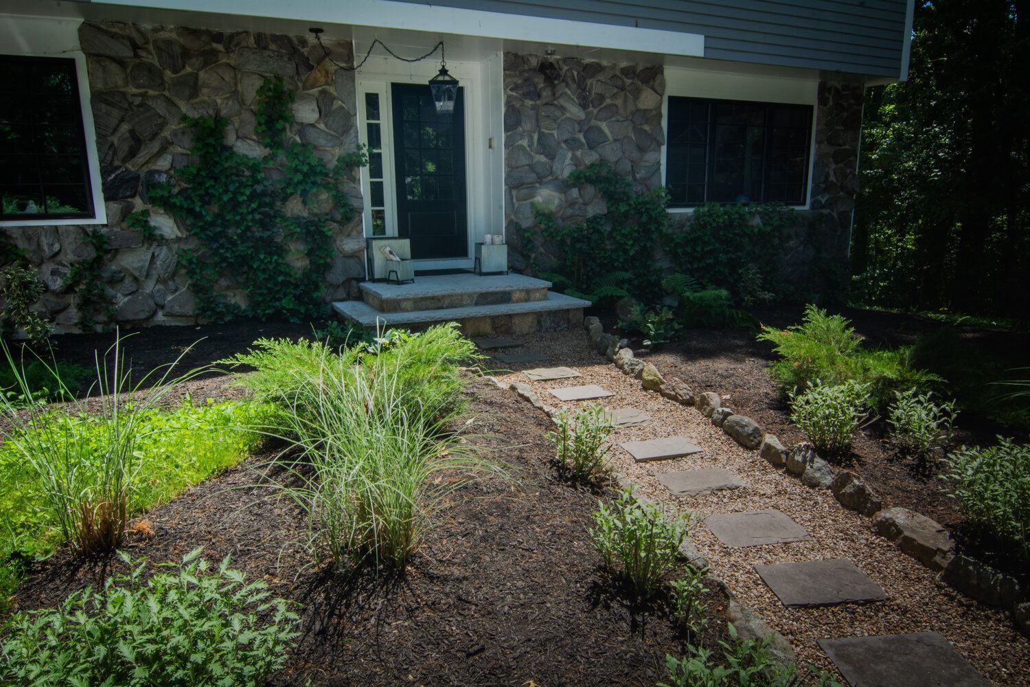 A stone house with a stone walkway leading to the front door.