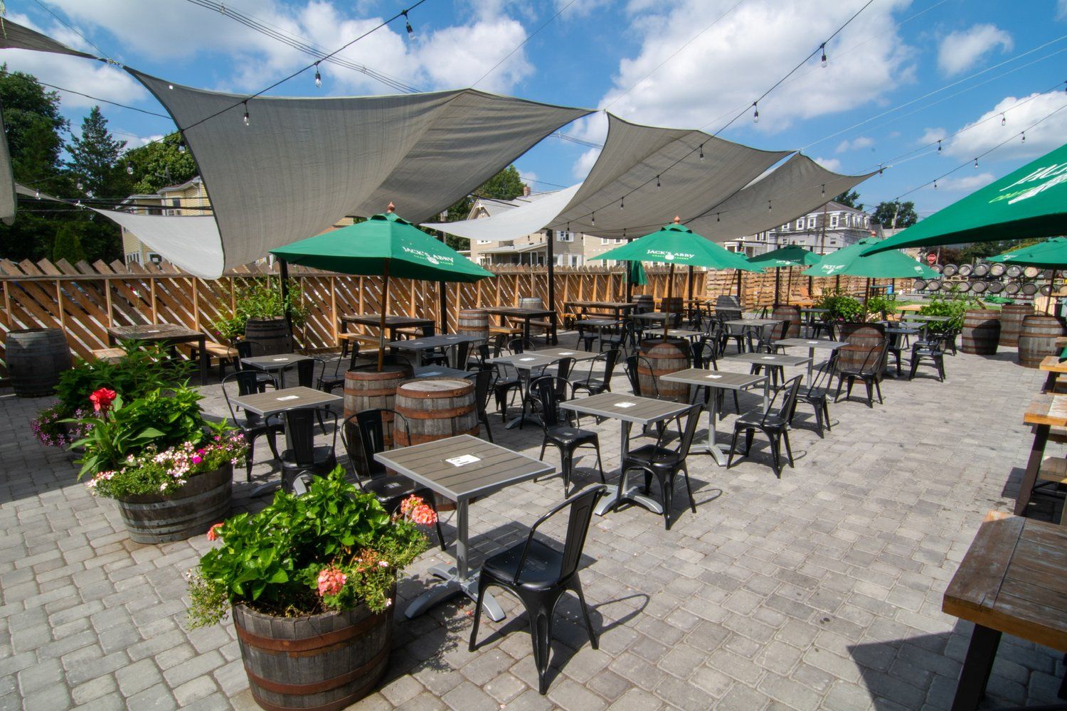 A patio with tables and chairs and umbrellas on a sunny day