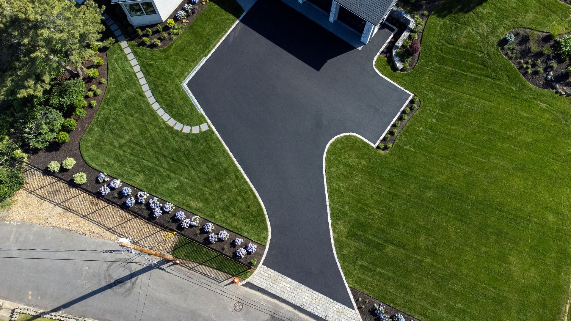 An aerial view of a driveway in front of a house.