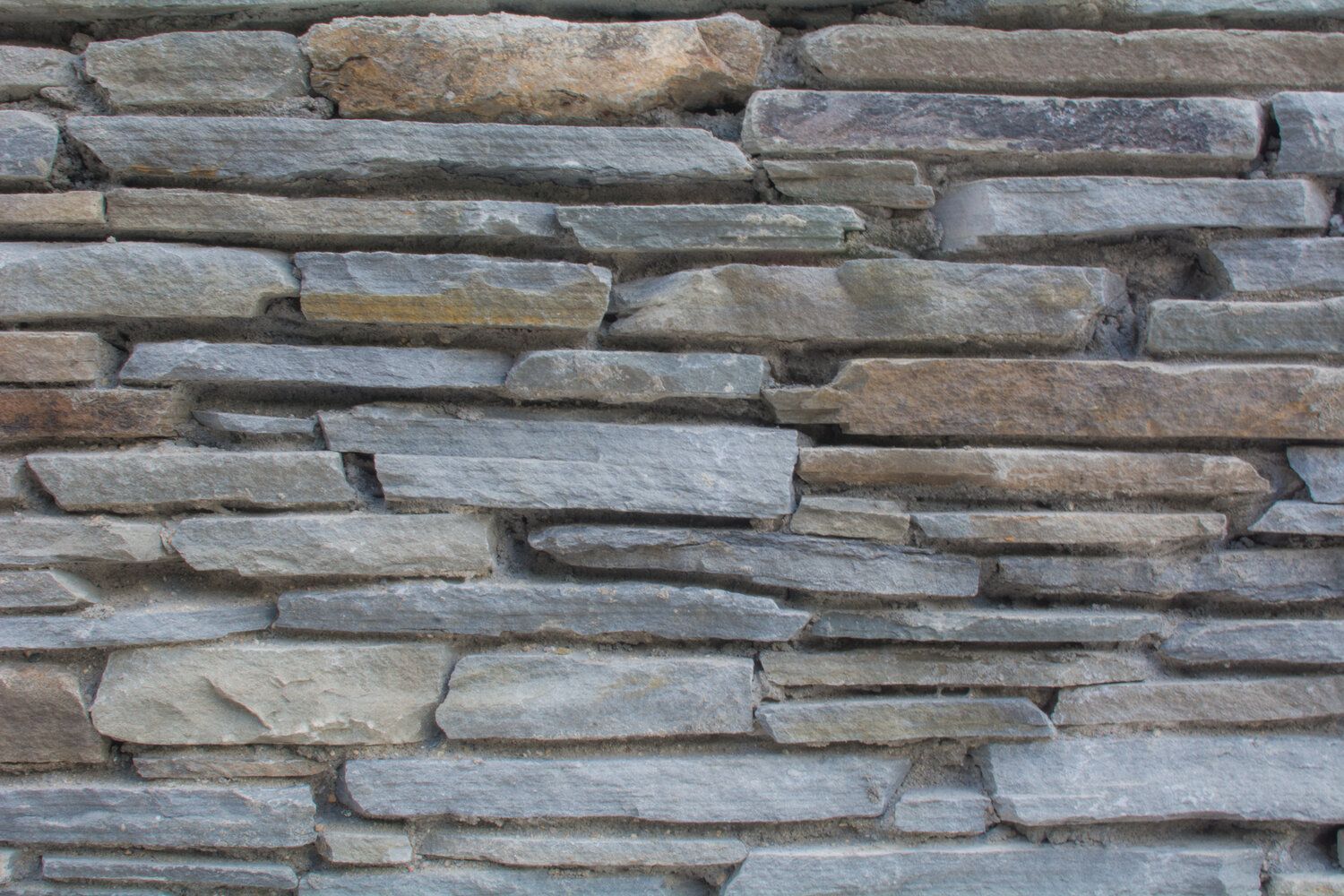 A close up of a stone wall made of different types of rocks.