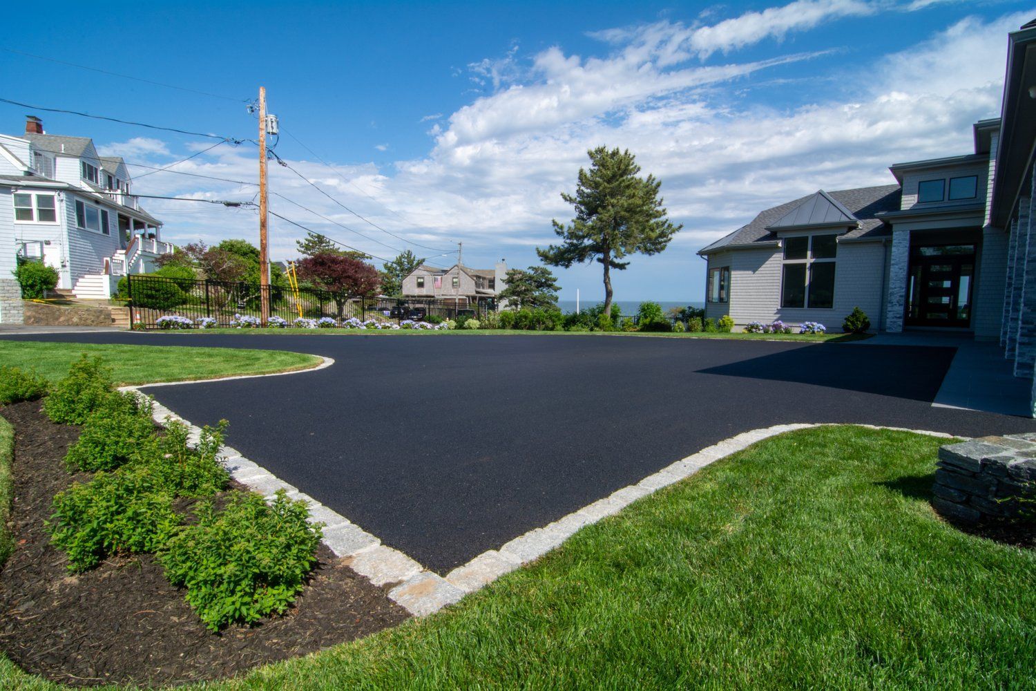 A driveway leading to a house on a sunny day.