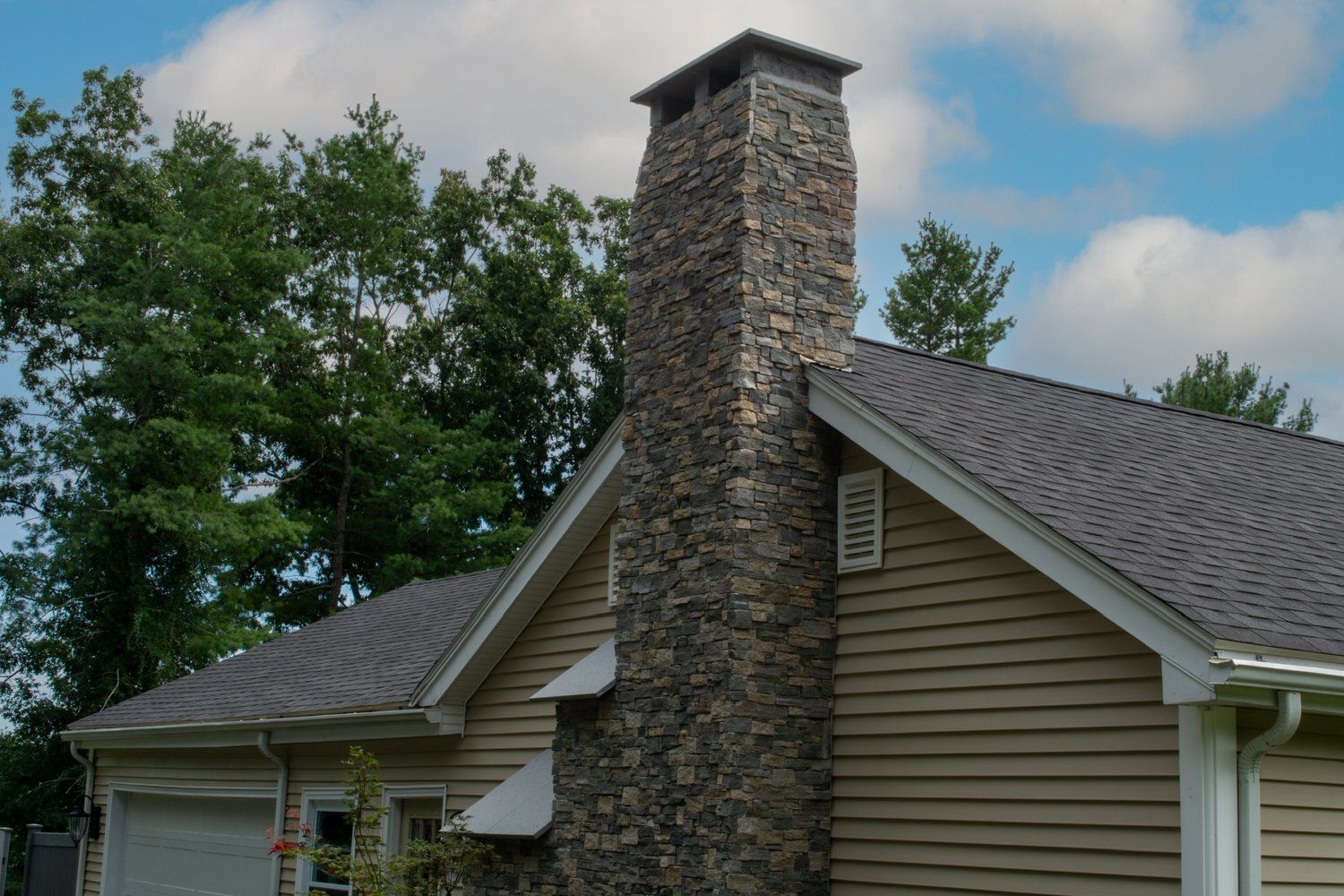 A house with a stone chimney on the side of it
