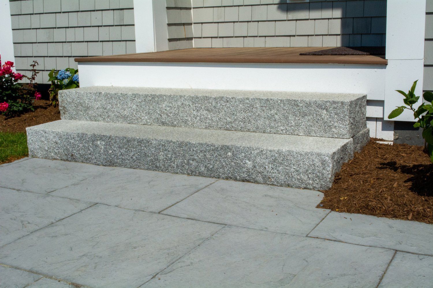 A set of granite steps leading up to a porch