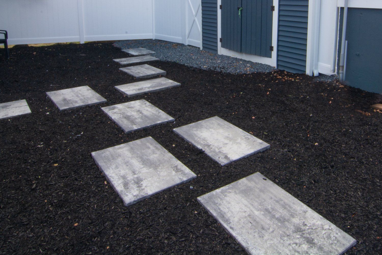A row of concrete stepping stones leading to a building.