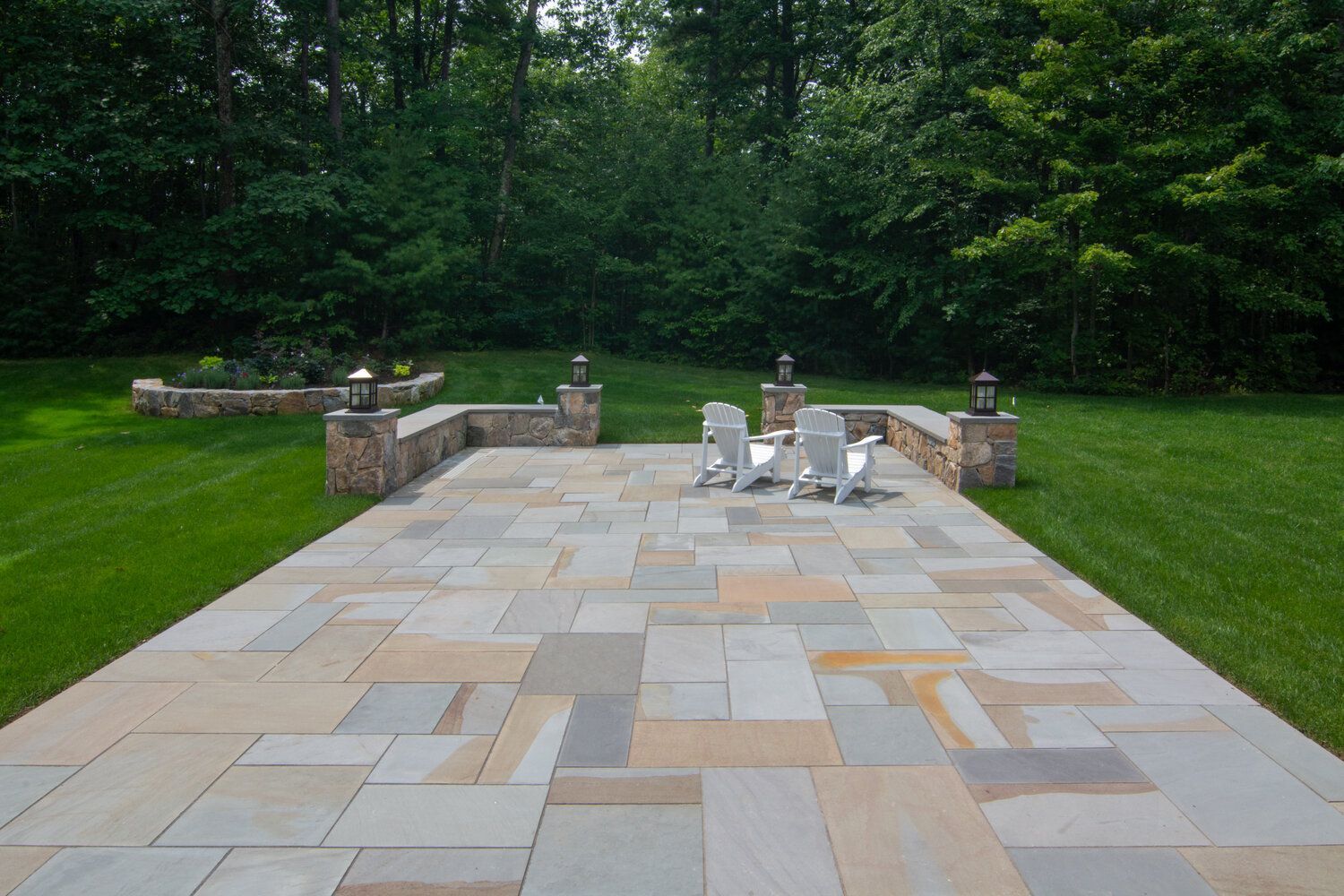 A large patio with chairs and trees in the background.