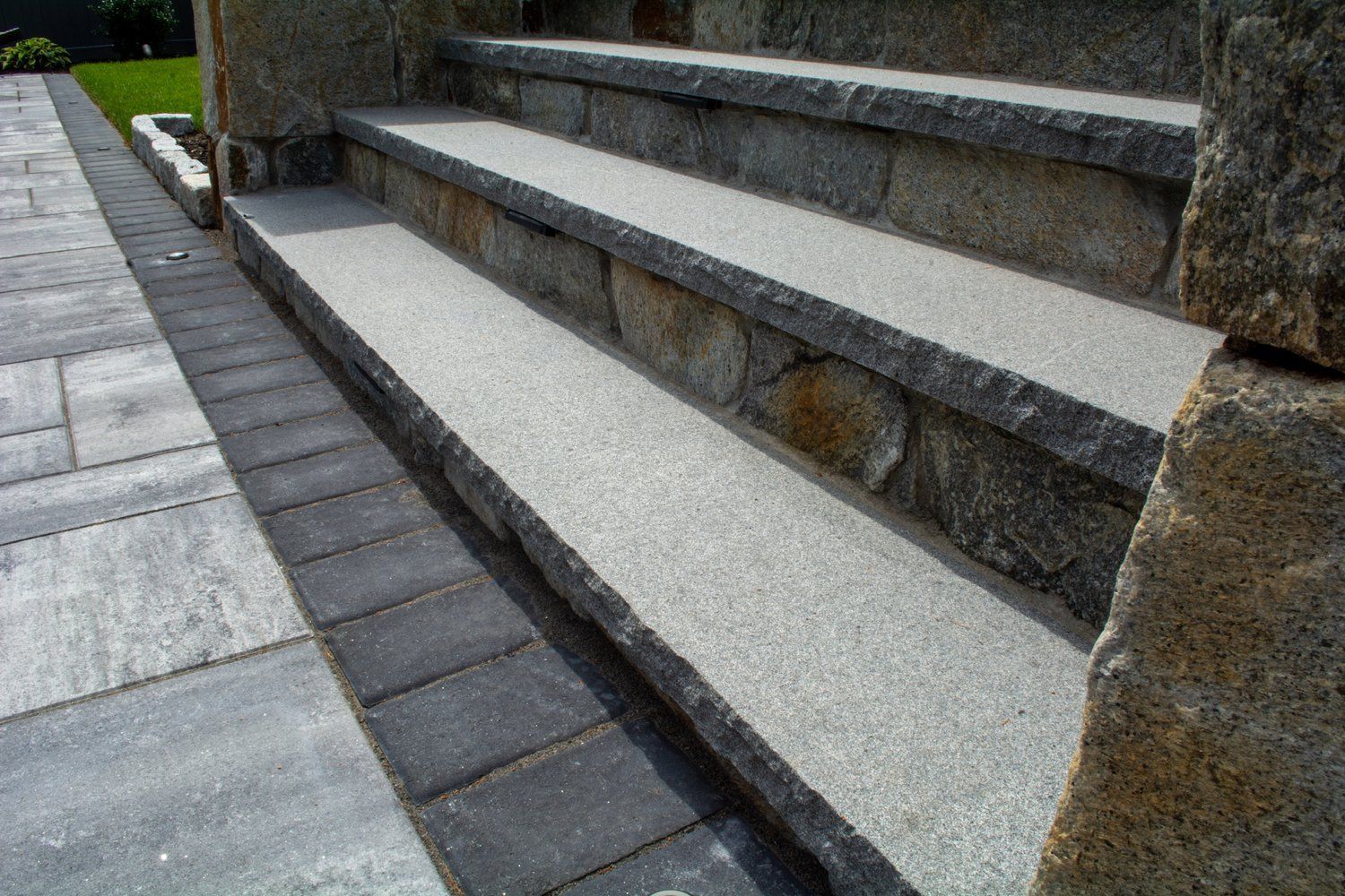A set of stone steps leading up to a stone wall.