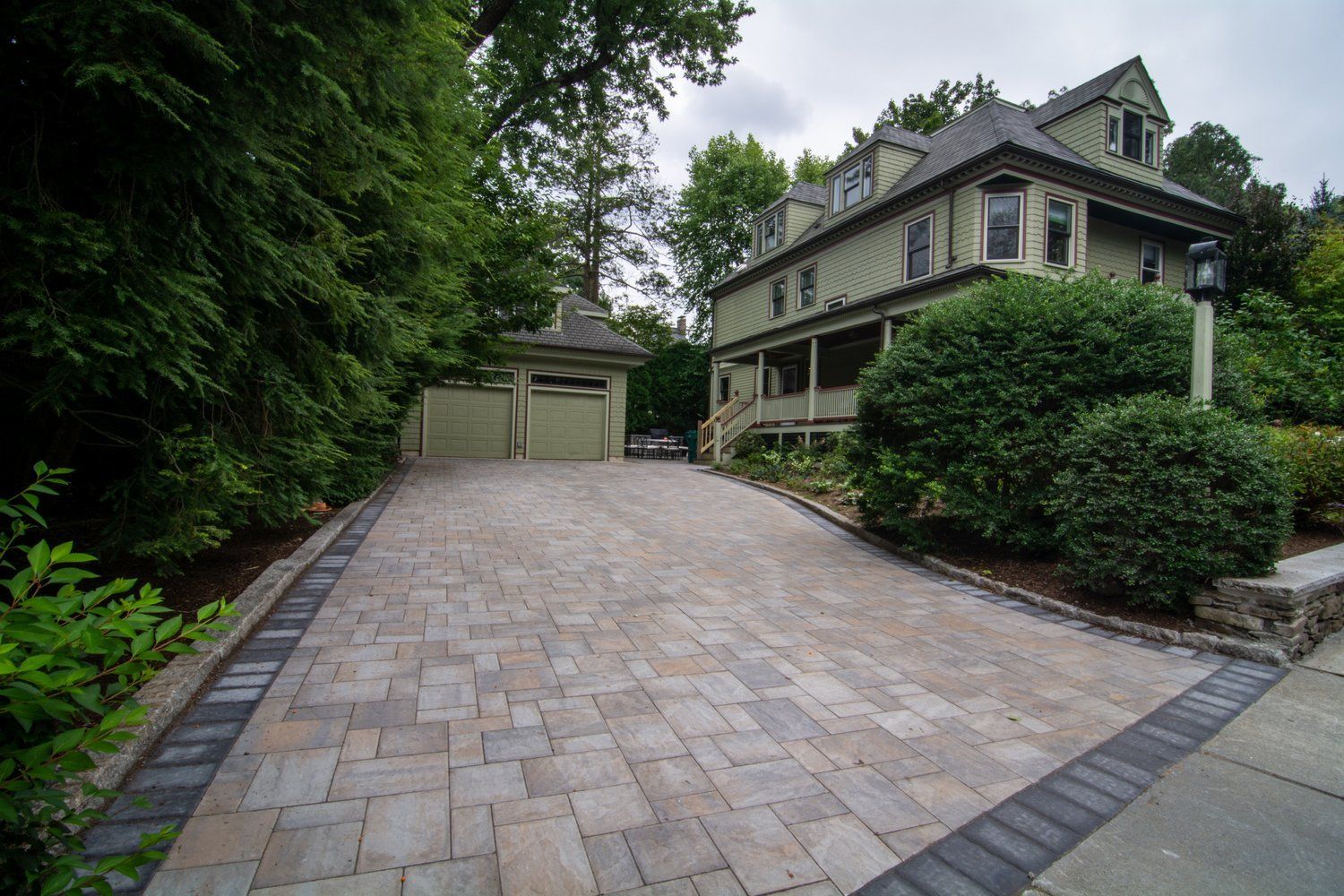 A large house with a brick driveway leading up to it.