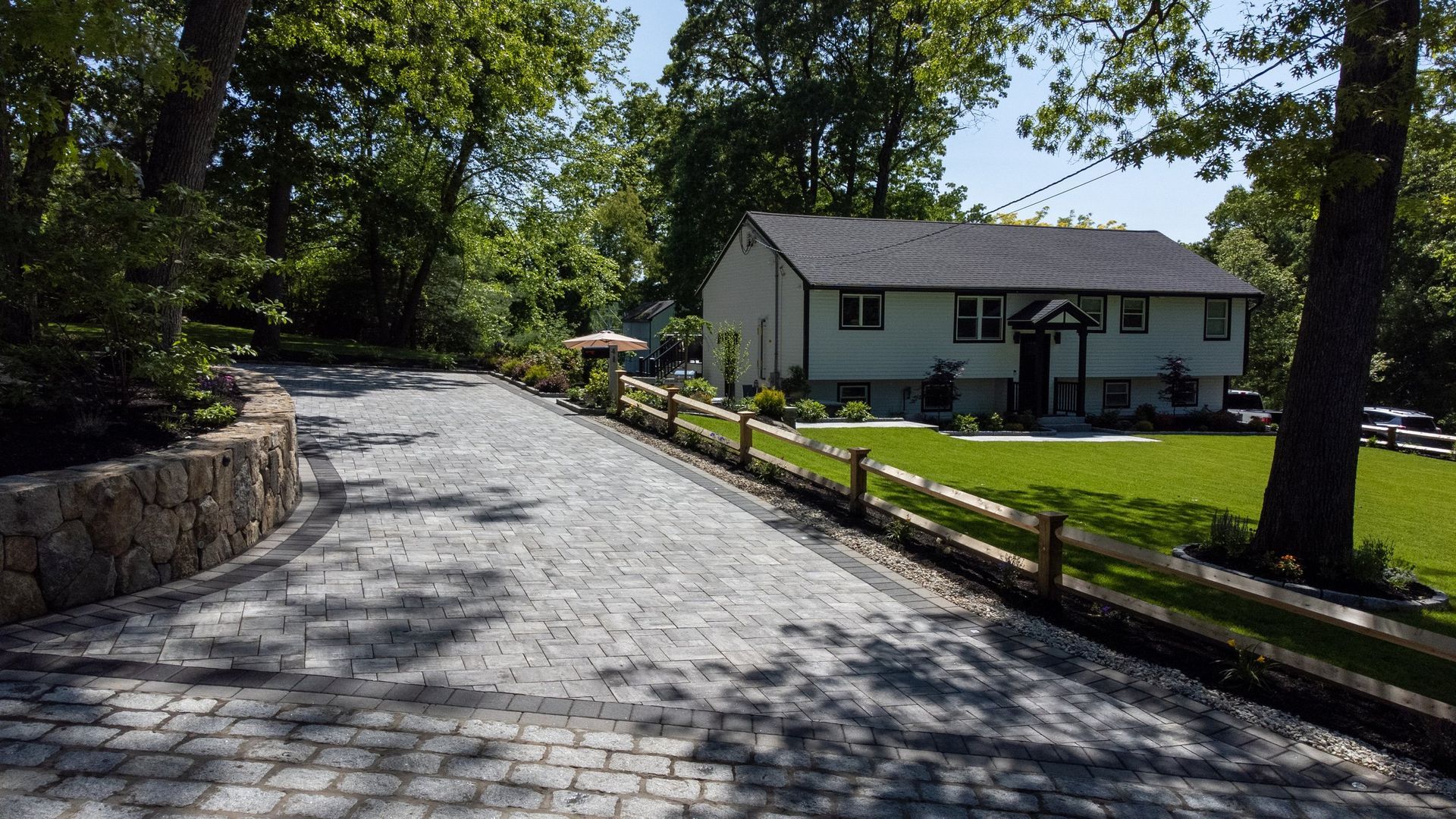 A driveway leading to a house surrounded by trees