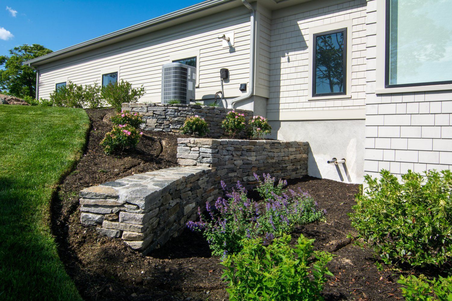 A white brick house with a stone walkway leading to the front door.
