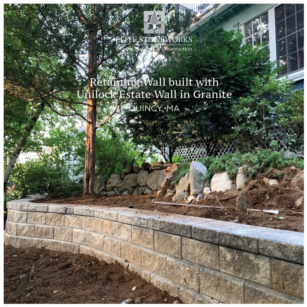A stone wall is being built in front of a house.